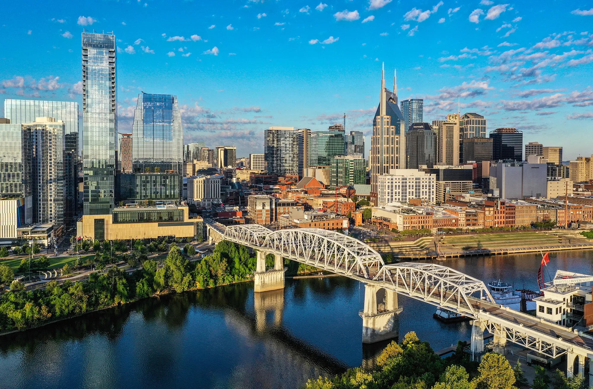 View of nashville skyline with the AT&T building and white pedestrian bridge over the river.
