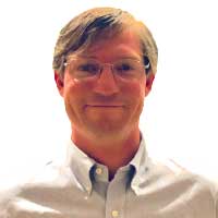 Person wearing glasses and a light-colored shirt with a white background